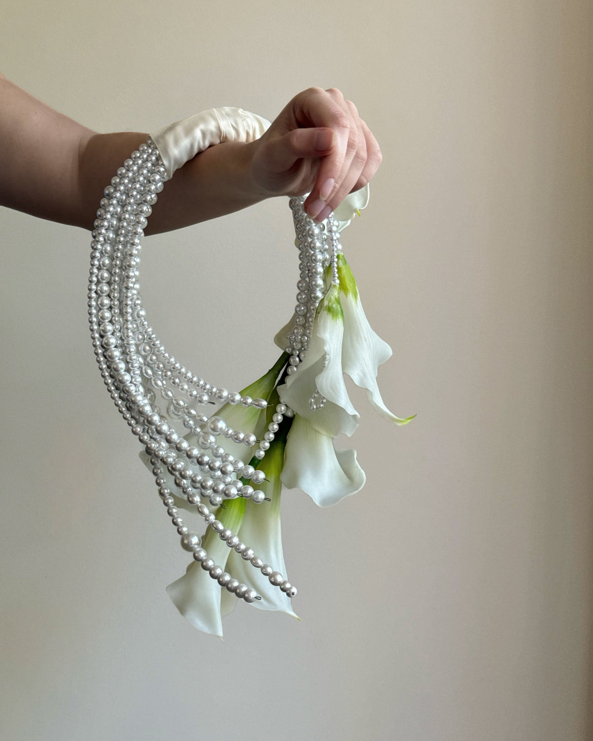 White bridal bouquet with calla lilies and pearl accents