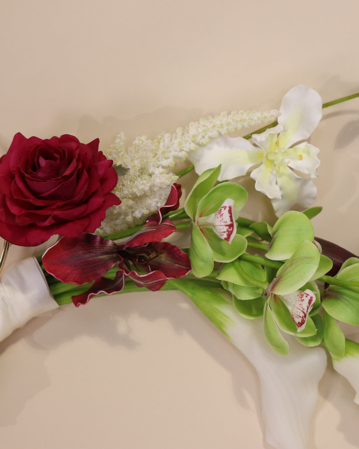 Burgundy Desire hoop bouquet featuring anthuriums, calla lilies and amaranth in rich burgundy tones with white and green accents.