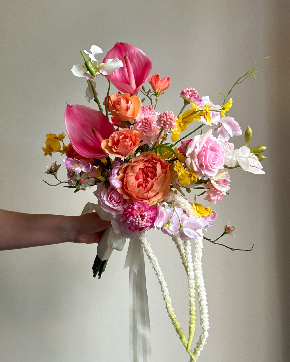 Tropical Punch bridal bouquet featuring bright, colourful real-touch flowers with satin ribbon-wrapped handle.