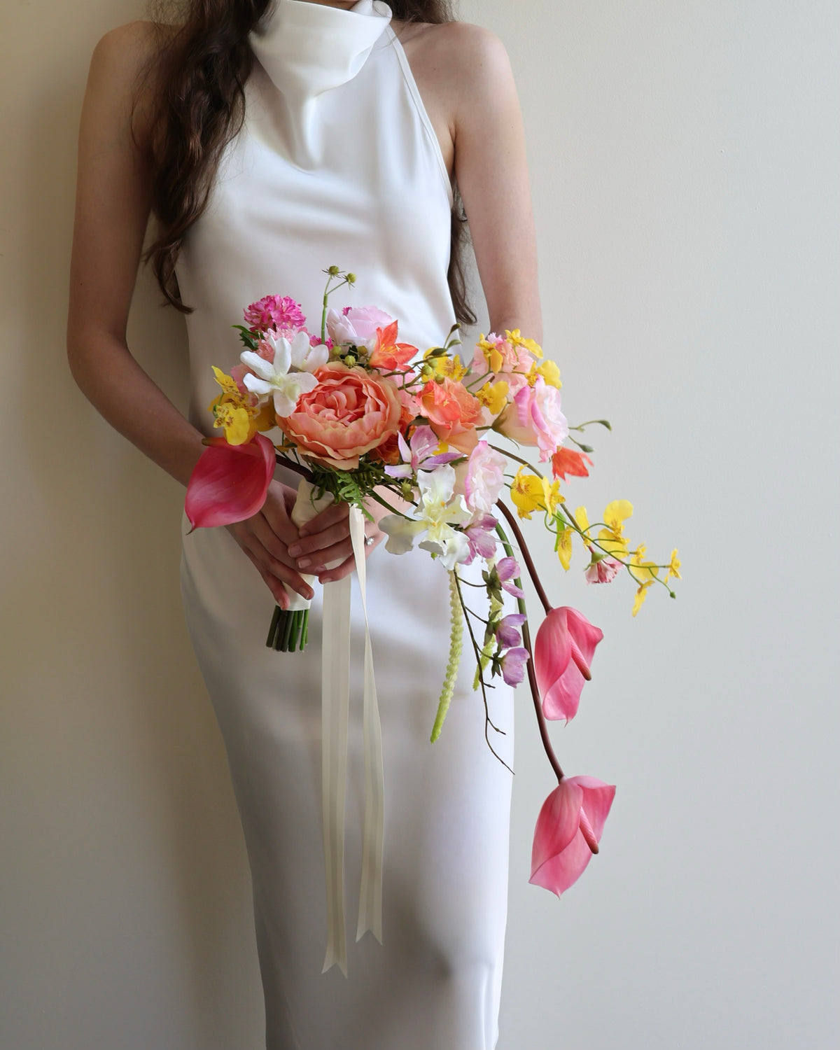 Tropical Punch cascading bouquet featuring bright, colourful real-touch flowers with satin ribbon-wrapped handle.